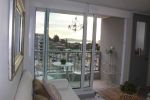 a living room with a couch and a balcony with a table at Lindo departamento vista al mar in Coquimbo