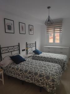 a bedroom with two beds and a window at Apartamento Buen Recuerdo in Camarena de la Sierra