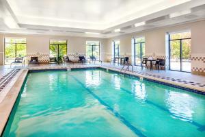a swimming pool with blue water in a room with windows at Courtyard by Marriott Boston Billerica Bedford in Billerica
