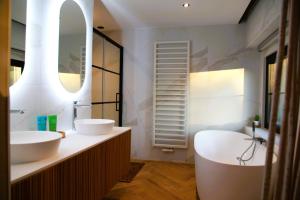 une salle de bain avec deux lavabos et un grand miroir dans l'établissement Dionbulles & Dionlodge Guesthouse, Private Wellness pool in option, à Chaumont-Gistoux