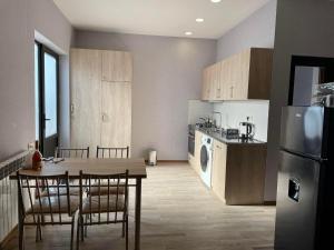 a kitchen with a table and chairs and a refrigerator at Bakuriani - Happy Yard in Bakuriani