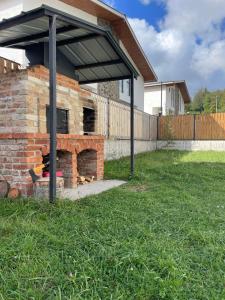 a brick fireplace in a yard with a roof at Bakuriani - Happy Yard in Bakuriani