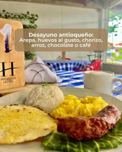 a plate of breakfast food with eggs rice and meat at HIDALGO HOTEL in Palmira