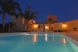 a swimming pool in front of a house at night at Torre Tabia in Sciacca