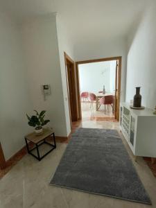 a living room with a table and a large rug at Appartement T1 Centre Pombal in Pombal