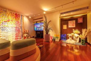 een woonkamer met een bank en een tv bij 曼谷夏日马卡龙别墅民宿 in Bangkok