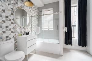 uma casa de banho com um WC, um lavatório e um espelho. em Les Lofts du Plateau em Montréal