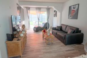a living room with a couch and a tv at La Maison des Plaisirs Love room in Champigny-sur-Yonne