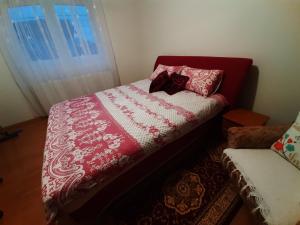 een slaapkamer met een bed met een rood en wit dekbed bij APARTMAN ILIDZA- KUCA DVA SPRATA in Ilidza