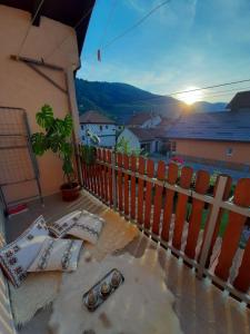 een balkon met een tafel en stoelen en uitzicht op de zonsondergang bij APARTMAN ILIDZA- KUCA DVA SPRATA in Ilidza