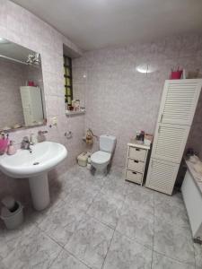 a bathroom with a white sink and a toilet at zielone Bemowo zaprasza in Warsaw