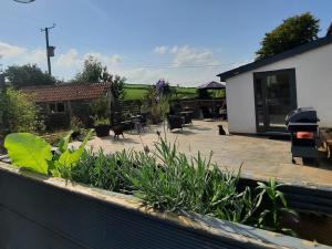 a backyard with a patio with chairs and plants at Longstone Luxury Country Boutique Two Bedroom Cottage, Exmoor, Challacombe, North Devon in Challacombe