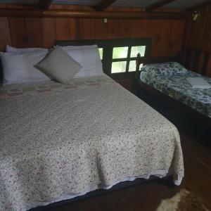 ein Schlafzimmer mit einem Bett mit einer weißen Bettdecke in der Unterkunft Sítio do Sol quádruplo wc privativo in Guabiruba
