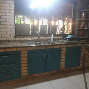 eine Küche mit blauen Schränken und einer Arbeitsplatte in der Unterkunft Sítio do Sol quádruplo wc privativo in Guabiruba