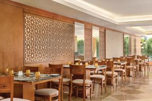 a restaurant with tables and chairs in a room at Vivid Jeddah Hotel, a member of Radisson Individuals in Jeddah