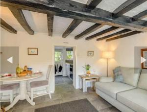 un soggiorno con divano e tavolo di Stone Cottage, Idyllic Village a Ingham