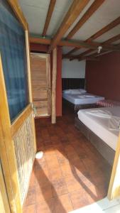 a room with two beds and a window at Cabañas Palos Locos in Baru