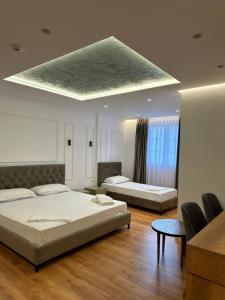 1 dormitorio con 2 camas y techo en Pashkaj Hotel, en Pogradec