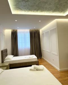 Cette chambre comprend 2 lits et une fenêtre. dans l'établissement Pashkaj Hotel, à Pogradec