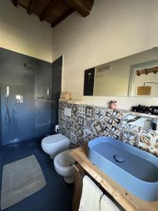 a bathroom with two toilets and a blue sink at The Loft By Birillo in Poggibonsi