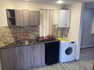 a kitchen with a washing machine and a sink at GuestHouse in Gyumri