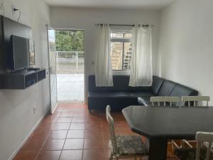 uma sala de estar com um sofá e uma mesa em Residencial Mizinho em Florianópolis