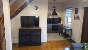 ein Wohnzimmer mit einem TV und einer Küche in der Unterkunft Zbychowskie Zacisze in Zbychowo