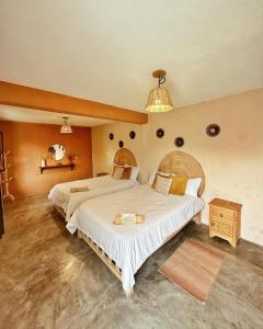Habitación grande con 2 camas y lámpara de araña. en Casa Sofia Guest House en San Cristóbal de Las Casas