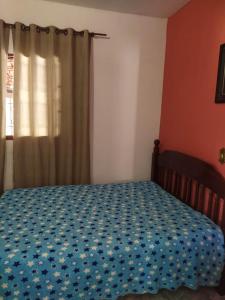 um quarto com uma cama com um edredão azul em Chácara do Juscelino em Monte Sião