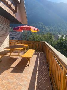 a patio with a picnic table and an umbrella at Karavanke Holiday Getaway in Hrušica