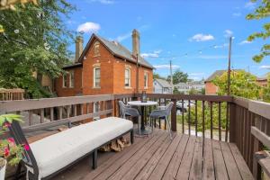 eine Holzterrasse mit einer Bank und einem Tisch in der Unterkunft Port CBus. Near OSU, Dining, Fun in Columbus