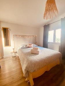 um quarto com uma cama com duas toalhas em Tiny Harmony - Logement confortable avec jardin et jacuzzi privés près d’Aix en Provence em Venelles