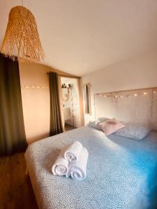 1 dormitorio con 1 cama con toallas en Tiny Harmony - Logement confortable avec jardin et jacuzzi privés près d’Aix en Provence, en Venelles