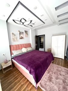 GRACELAND new apartment in Hurghada center في الغردقة: غرفة نوم مع سرير أرجواني كبير في غرفة