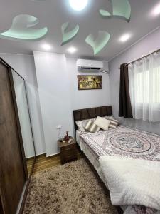 GRACELAND new apartment in Hurghada center في الغردقة: غرفة نوم مع سرير مع ديكورات خضراء على السقف