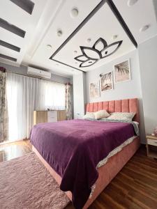 GRACELAND new apartment in Hurghada center في الغردقة: غرفة نوم بسرير كبير مع مفرش بنفسجي