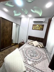 GRACELAND new apartment in Hurghada center في الغردقة: غرفة نوم مع سرير مع سجادة على السقف