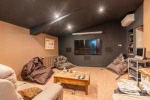 sala de estar con sofás, mesa y TV en Le Voyage d'Ulysse, en Marsillargues