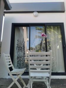 a pair of chairs sitting in front of a window at La Caz'A Loca in Saint-Pierre