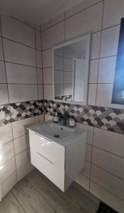 a bathroom with a white sink and a mirror at La Caz'A Loca in Saint-Pierre +2 photos