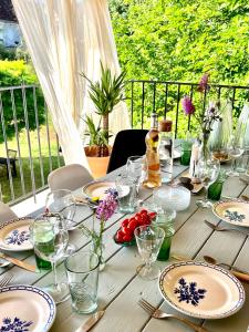 une table en bois avec des assiettes et des verres dans l'établissement Maison Fermontes, à Cazillac