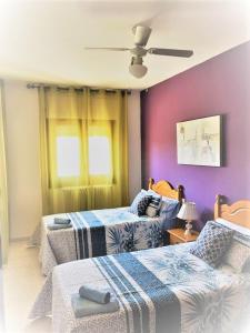 a bedroom with two beds and a ceiling fan at Esplús Casa Rural in Binéfar