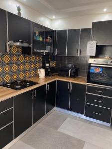 a kitchen with black cabinets and stainless steel appliances at Villa Mimi's in Sali Poulang