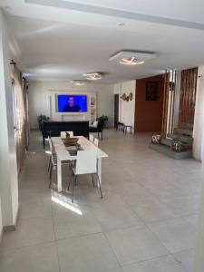 Sali Poulang的住宿－Villa Mimi's，客厅配有桌椅和电视。