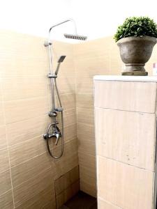 y baño con ducha en la pared. en Villa Mimi's en Sali Poulang