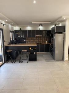 a large kitchen with black cabinets and stainless steel appliances at Villa Mimi's in Sali Poulang