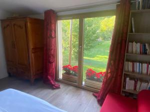 a bedroom with a window with a view of a yard at Apatam-Montigny, bord du Loing in Bourron-Marlotte