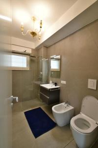 uma casa de banho com um WC, um lavatório e um espelho. em Palazzo Mosillo em Sperlonga