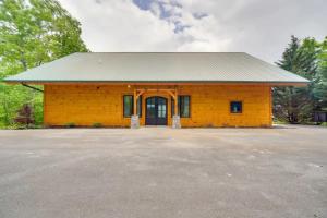 een geel gebouw met een zwarte deur op een parkeerplaats bij Sensational Views cabin in Pittman Center