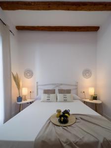 een slaapkamer met een wit bed en een dienblad bij Somos Genius! Siéntete como en casa, en el corazón de Tarragona in Tarragona